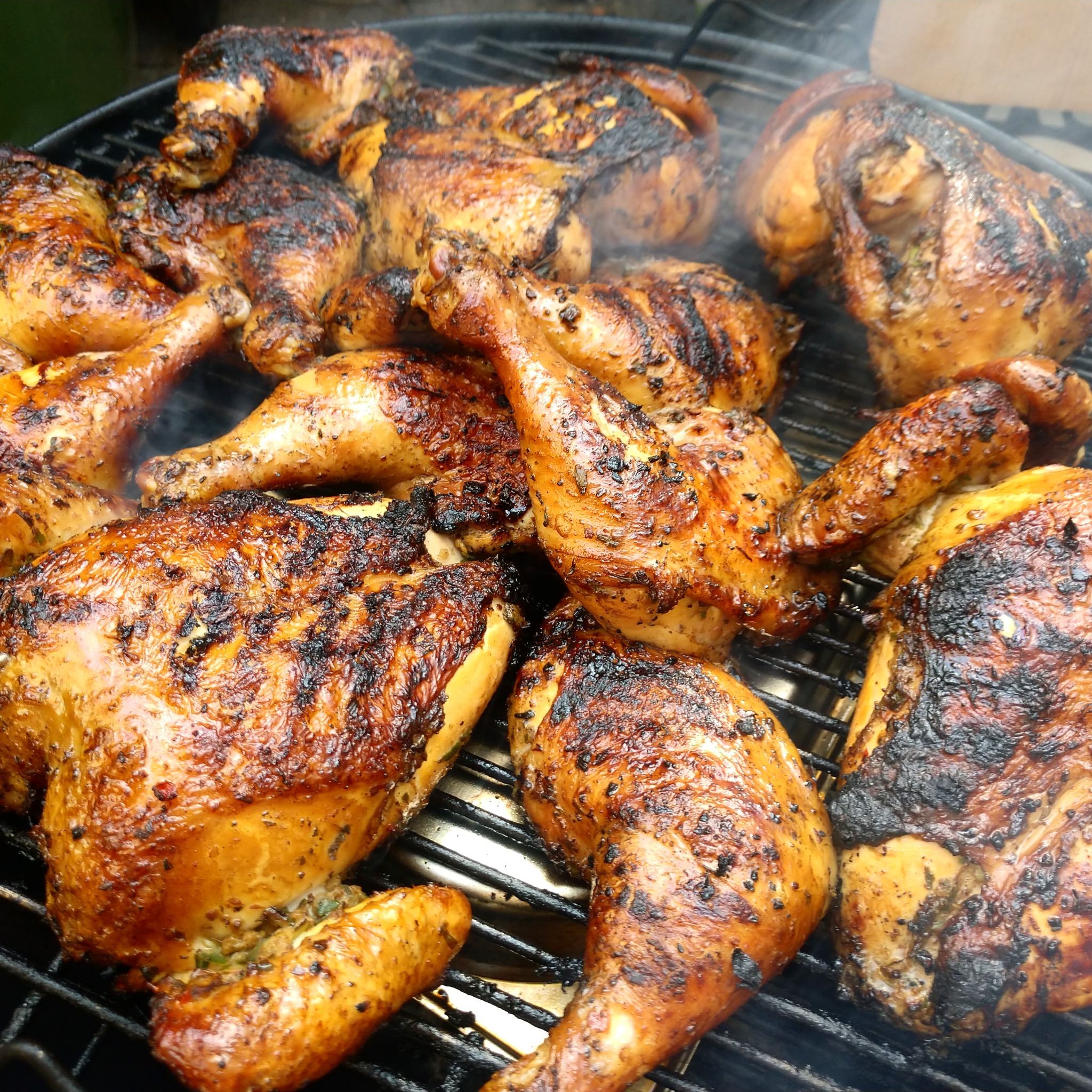 Herb-marinated chickens over fire
